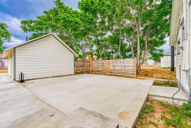 a view of a yard with plants and trees