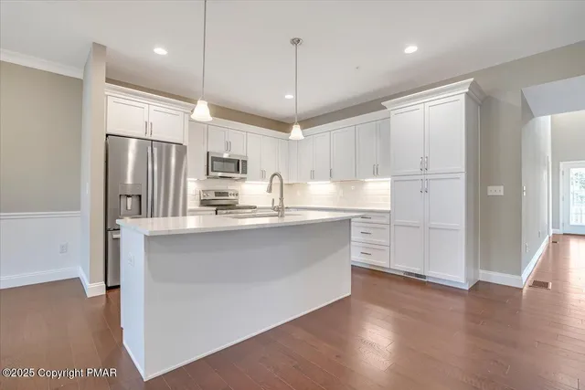 a view of an empty room with wooden floor fireplace and a window