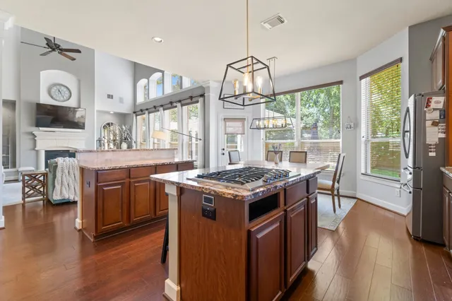 a kitchen with a stove and wooden floor