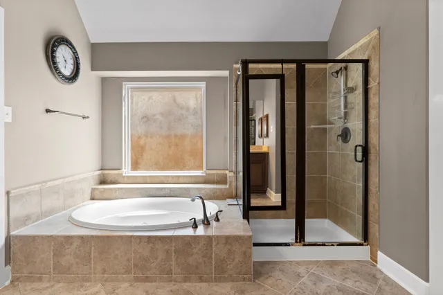 a bathroom with a tub a sink and a large mirror