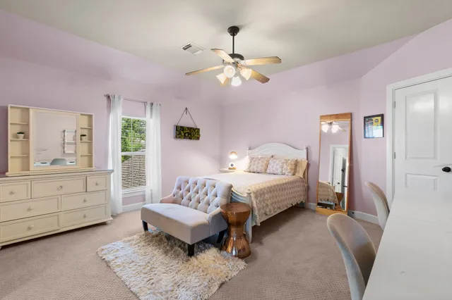 a spacious bedroom with a bed and a dresser