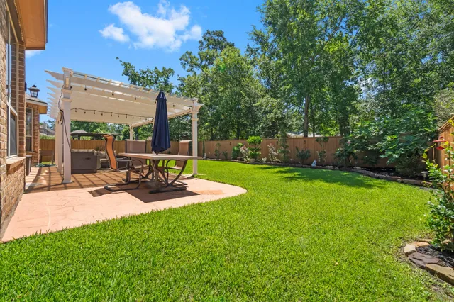 a view of a patio with table and chairs potted plants and palm tree