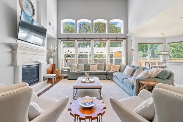 a living room with furniture a fireplace and a floor to ceiling window