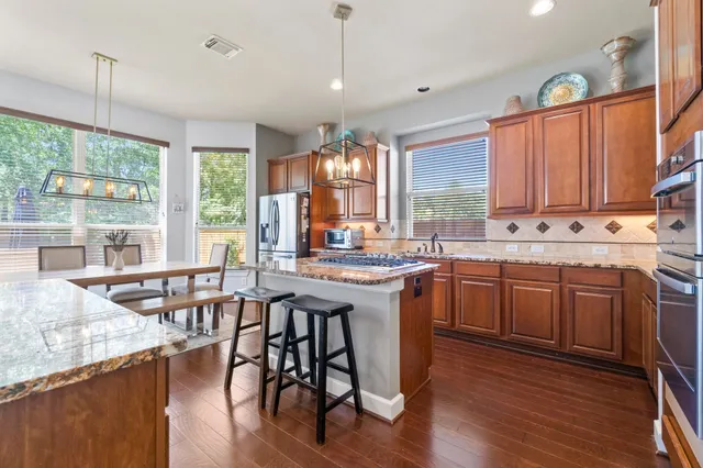 a kitchen with a sink a stove a dining table and chairs