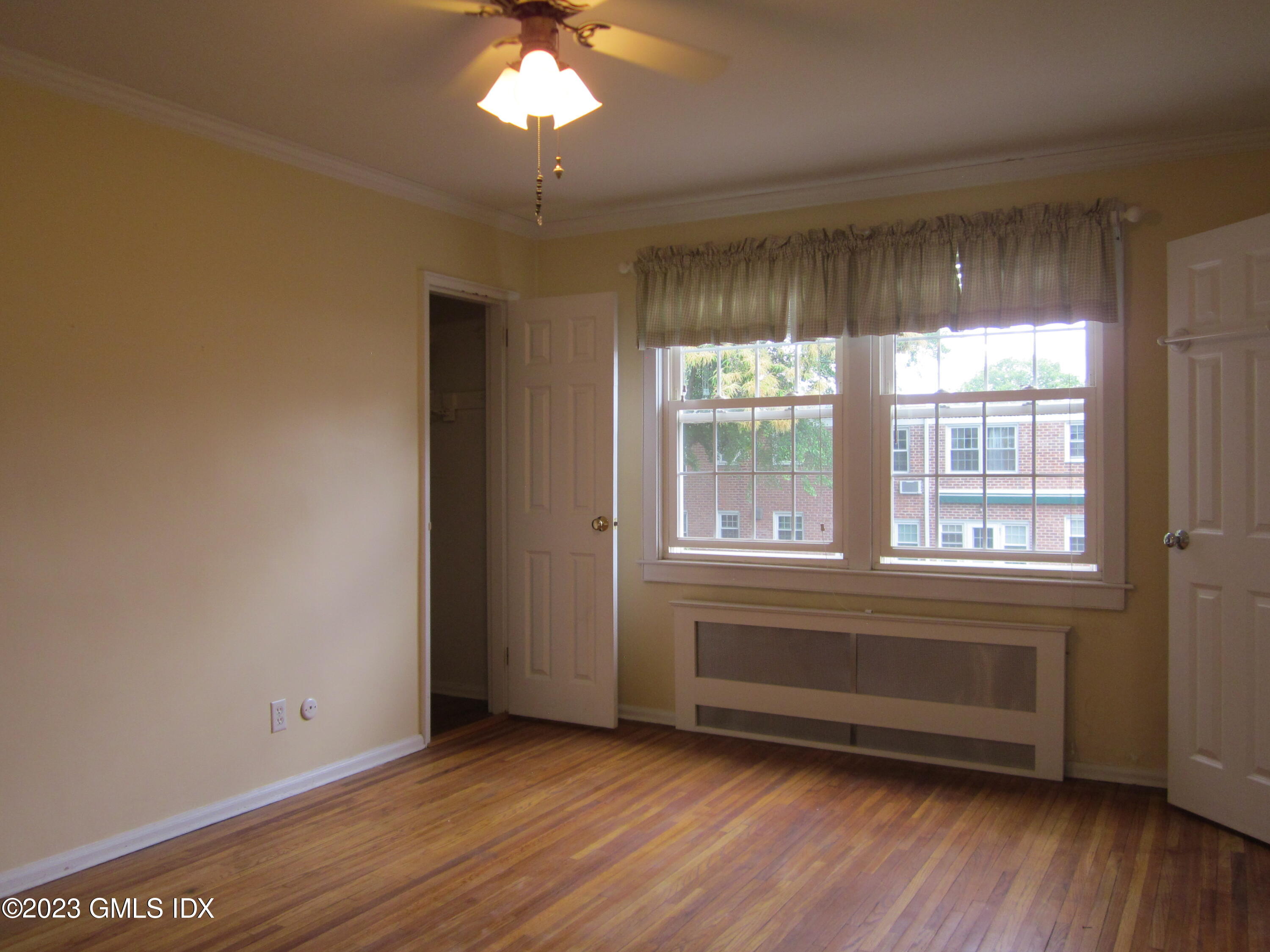 68 Putnam Park, Unit 68 Greenwich, CT 06830 - Photo 17 of 31 a view of an empty room with wooden floor and a window