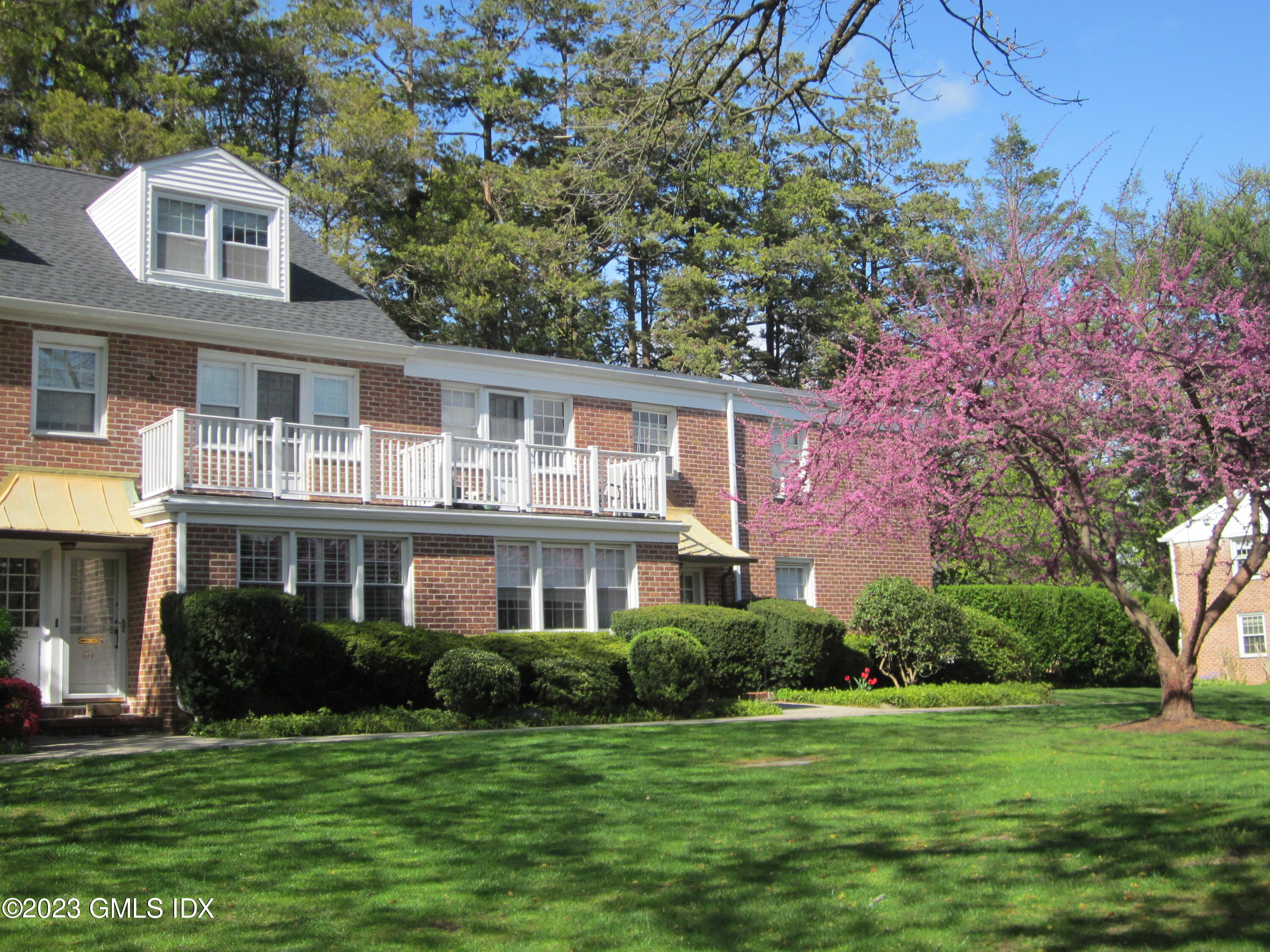 68 Putnam Park, Unit 68 Greenwich, CT 06830 - Photo 26 of 31 a front view of a house with a garden