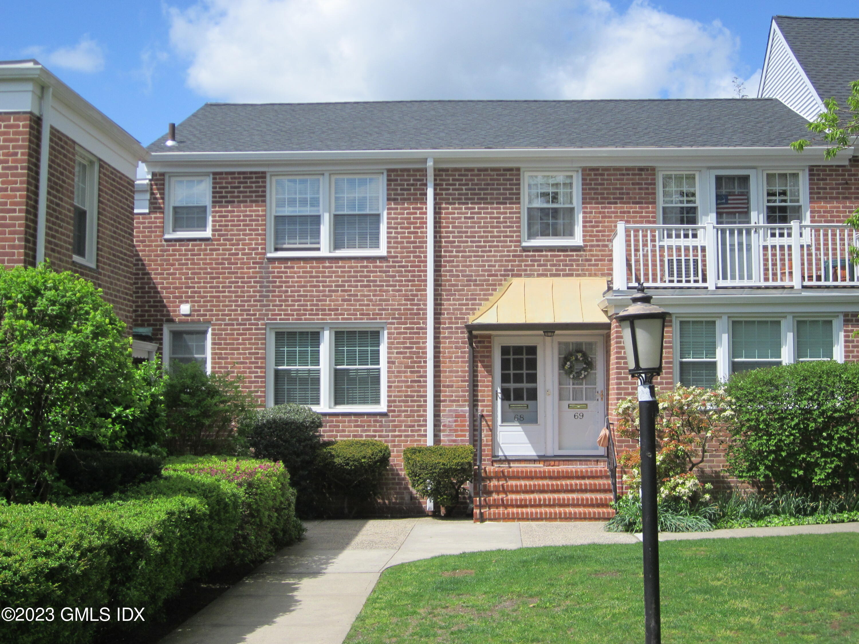 68 Putnam Park, Unit 68 Greenwich, CT 06830 - Photo 3 of 31 a front view of a house with a yard