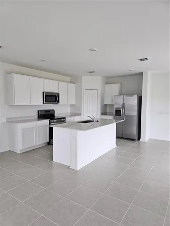 a large white kitchen with white cabinets