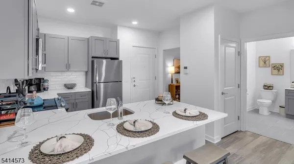 a kitchen with stainless steel appliances granite countertop a sink and a refrigerator