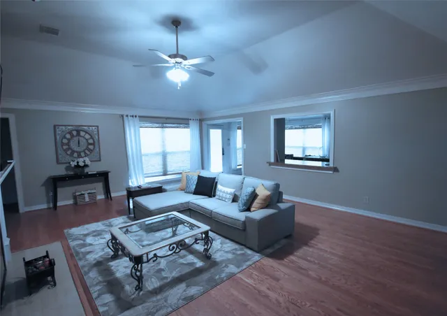 a living room with furniture and a wooden floor