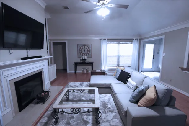 a living room with furniture a flat screen tv and a fireplace
