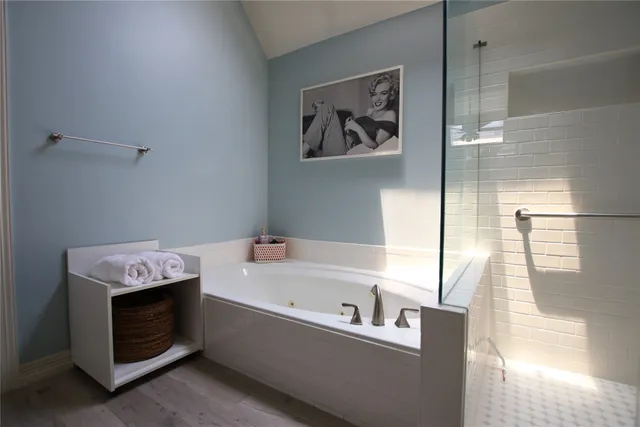 a bathroom with a tub a sink and a window