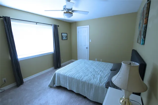 a bedroom with a bed and painting on the wall