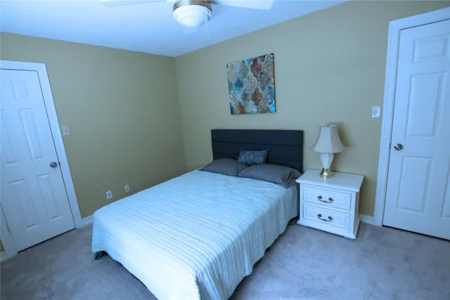 a spacious bedroom with a bed and a painting on the wall