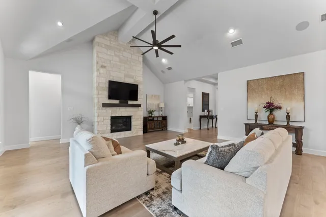 a living room with furniture a fireplace and a flat screen tv