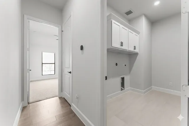 a view of a hallway with wooden floor and closet