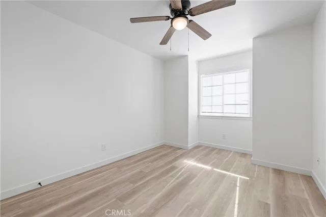 an empty room with windows and fan
