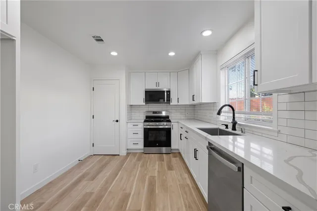 a view of a kitchen with a sink stove and cabinets