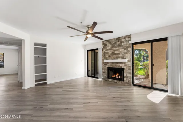 a view of an empty room with a fireplace and a window