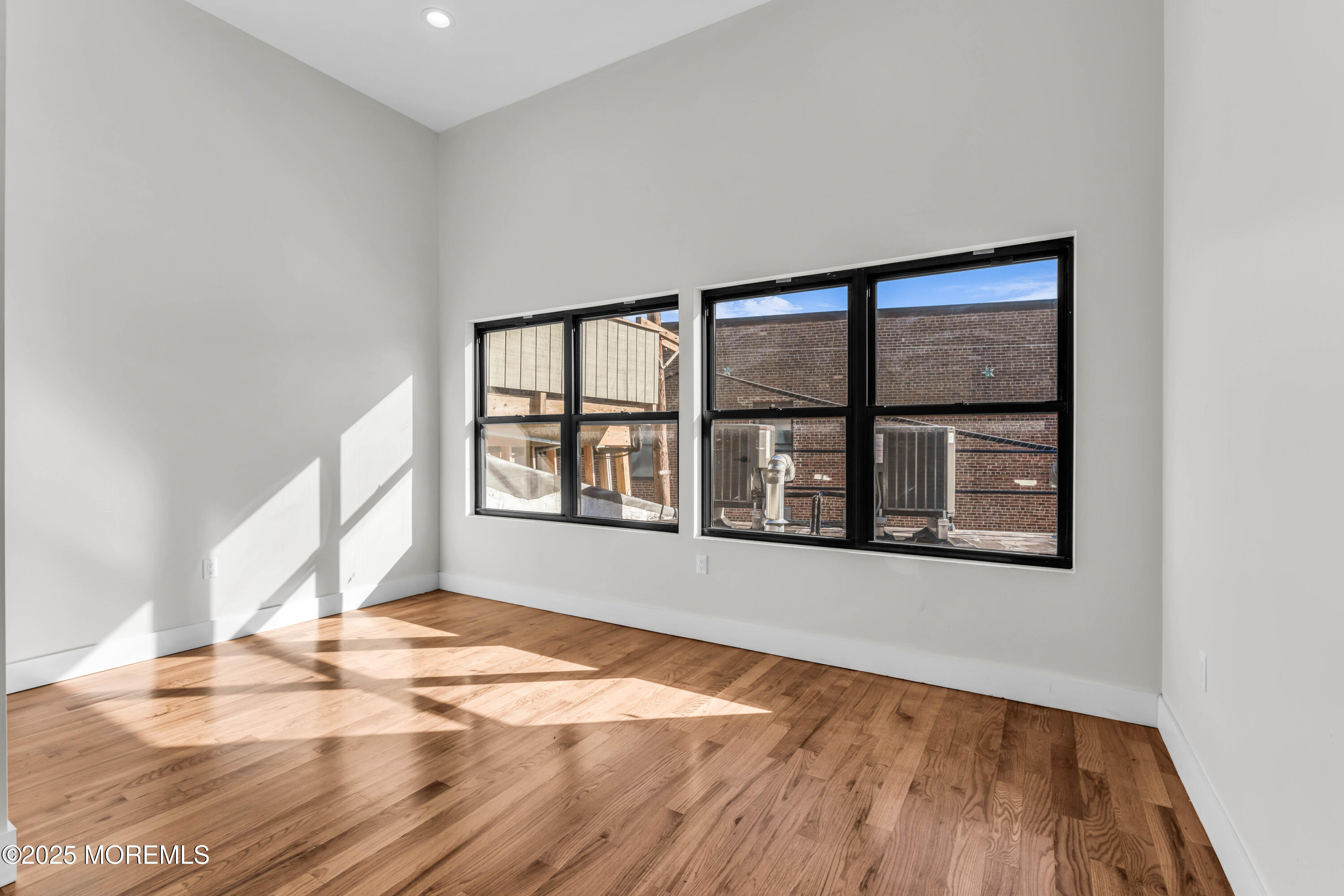 7 Broad Street, Unit 3 Red Bank, NJ 07701 - Photo 2 of 18 a view of an empty room with a window and wooden floor