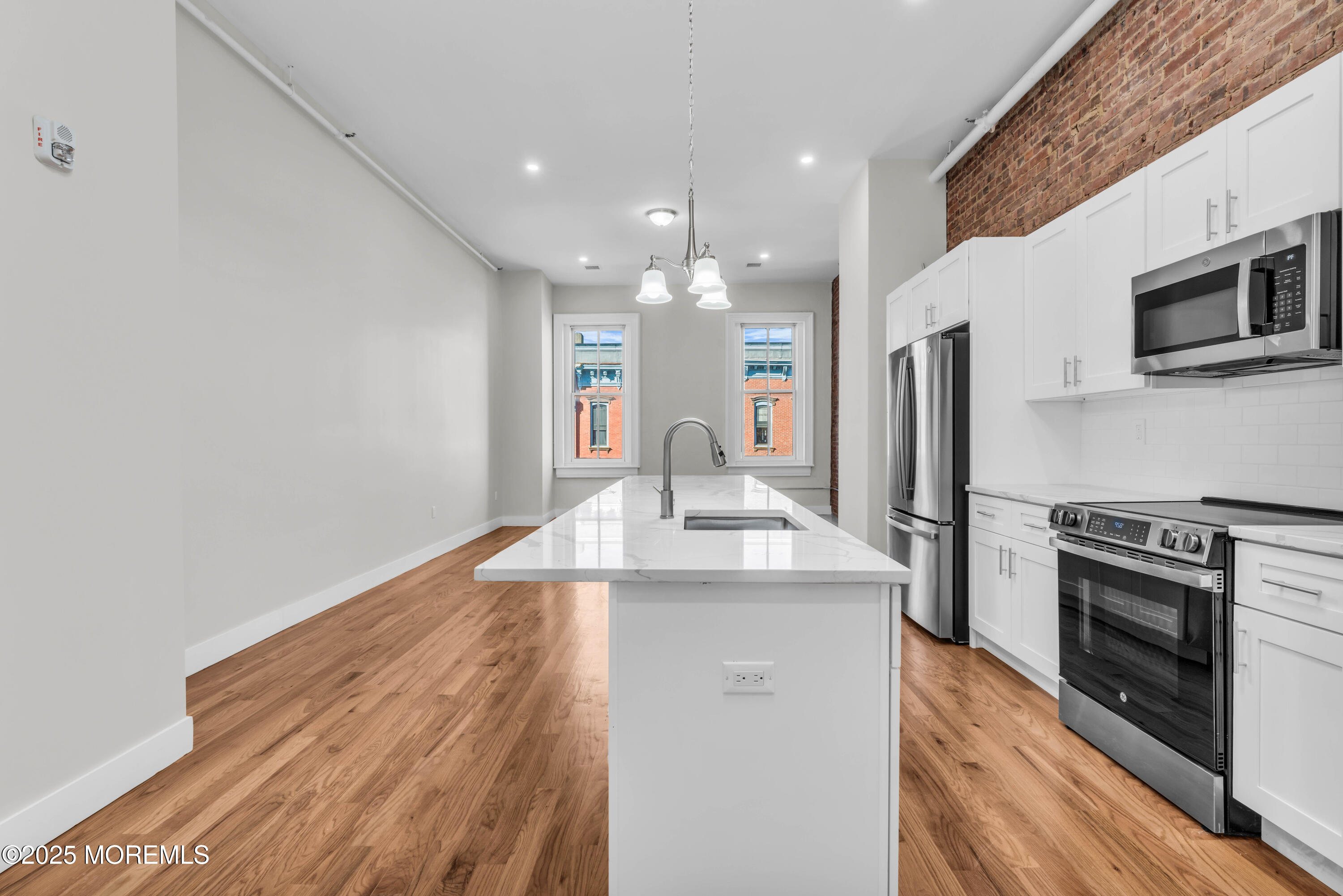 7 Broad Street, Unit 3 Red Bank, NJ 07701 - Photo 4 of 18 a kitchen with stainless steel appliances a stove top oven a sink and a refrigerator