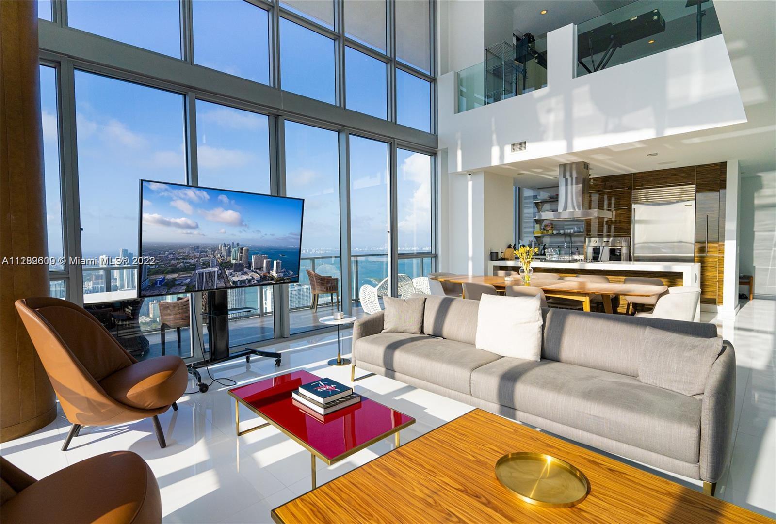 a living room with furniture and a floor to ceiling window