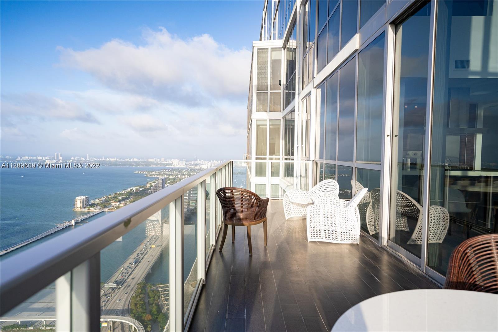 1100 Biscayne Boulevard, Unit 6307 Miami, FL 33132 - Photo 12 of 19 a balcony with wooden floor and outdoor seating