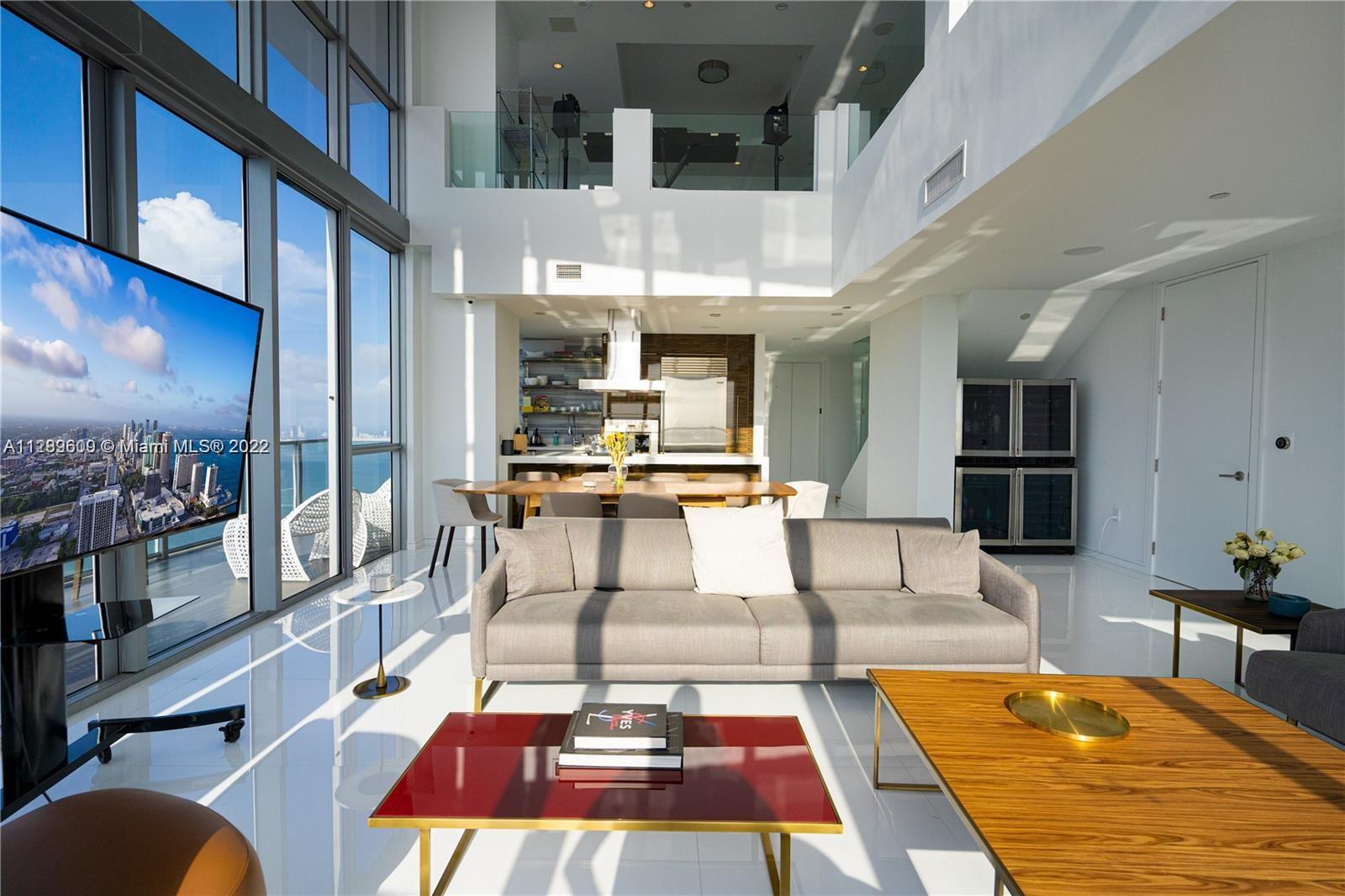 1100 Biscayne Boulevard, Unit 6307 Miami, FL 33132 - Photo 16 of 19 a living room with furniture a rug and kitchen view