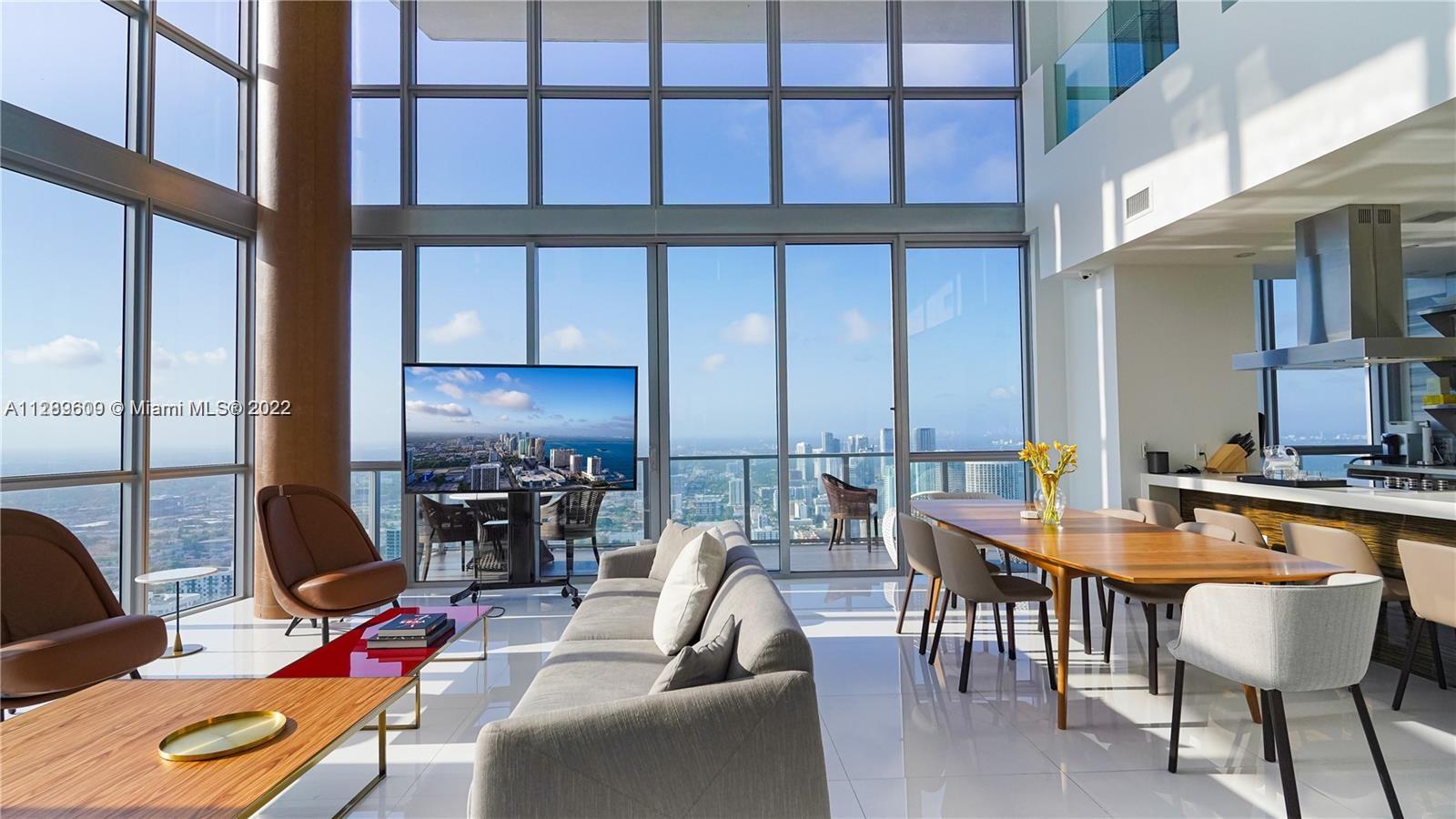 1100 Biscayne Boulevard, Unit 6307 Miami, FL 33132 - Photo 2 of 19 a dining room with furniture and a floor to ceiling window