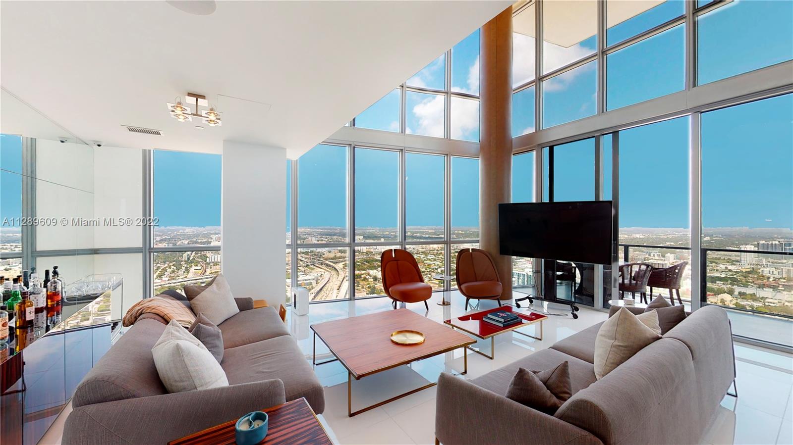 1100 Biscayne Boulevard, Unit 6307 Miami, FL 33132 - Photo 7 of 19 a living room with furniture a large window and a flat screen tv