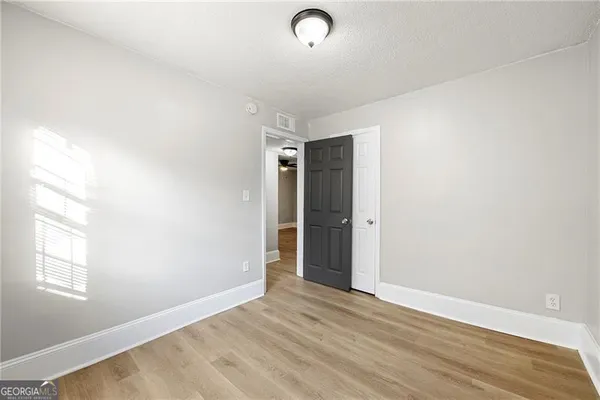 an empty room with wooden floor and windows