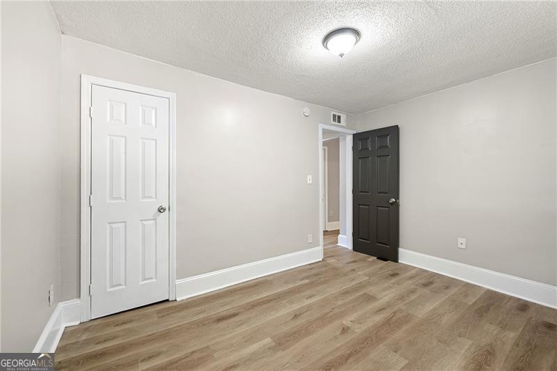 156 Fairfield Place Northwest Atlanta, GA 30314 - Photo 12 of 17 an empty room with wooden floor and windows