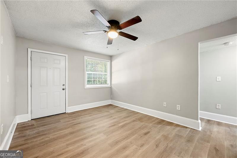156 Fairfield Place Northwest Atlanta, GA 30314 - Photo 2 of 17 a view of an empty room with wooden floor and a ceiling fan