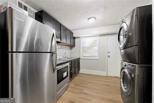 a kitchen with stainless steel appliances granite countertop a refrigerator and a stove