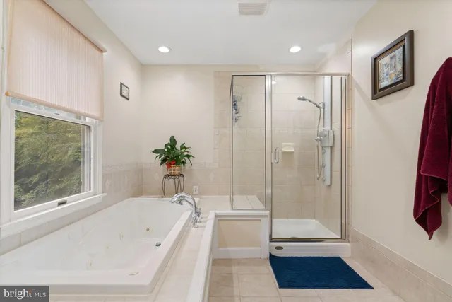a bathroom with a tub shower and window