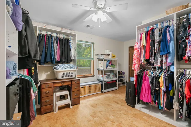 a view of walk in closet with clothes and shoes