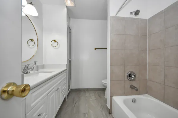 a bathroom with a tub sink and mirror