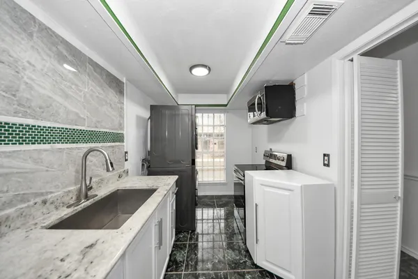 a kitchen that has a sink and a stove in it