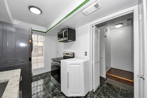 a kitchen with a refrigerator and a stove