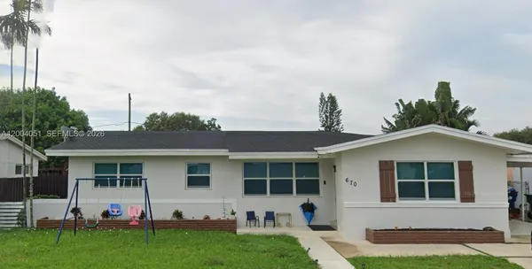 a front view of a house with a yard and outdoor seating