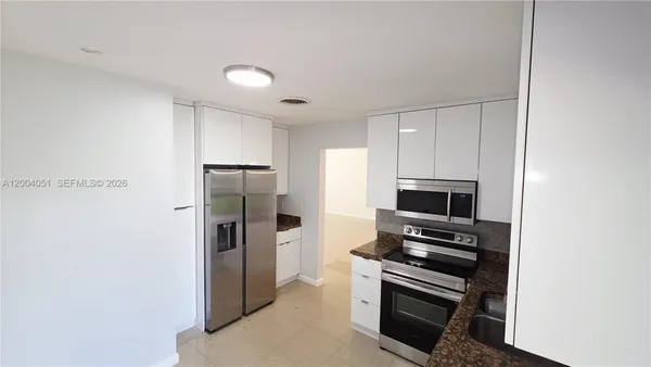 a kitchen with stainless steel appliances a refrigerator and a stove top oven