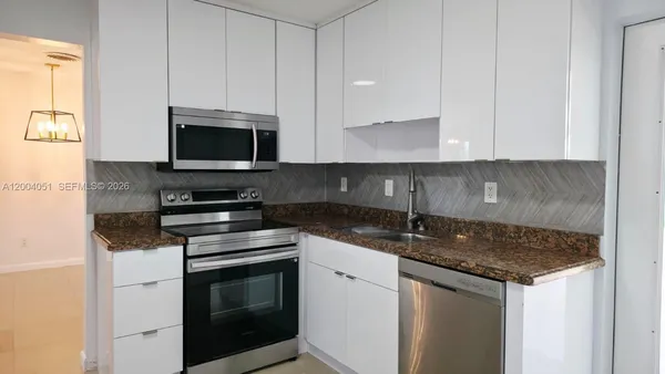 a kitchen with granite countertop a sink and a stove top oven