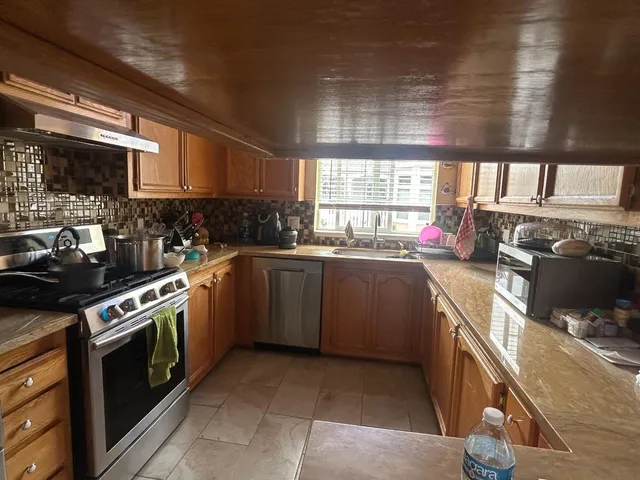 a kitchen with stainless steel appliances a sink dishwasher stove and oven