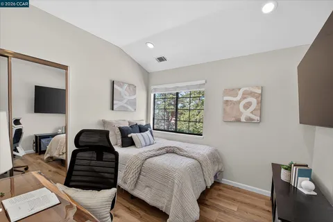 a bedroom with a bed and wooden floor