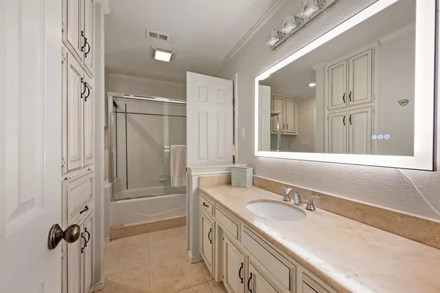 a bathroom with a granite countertop sink a mirror and a bathtub