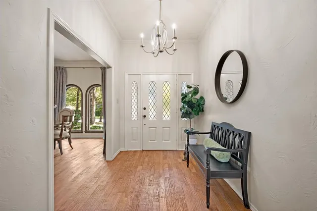 a view of a hallway with wooden floor and a large mirror