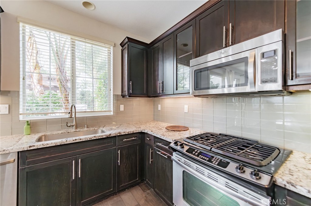 166 Desert Bloom Irvine, CA 92618 - Photo 12 of 36 a kitchen with stainless steel appliances granite countertop a sink a stove and cabinets