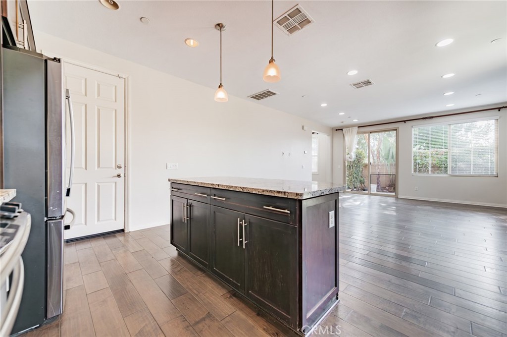 166 Desert Bloom Irvine, CA 92618 - Photo 14 of 36 a kitchen with stainless steel appliances granite countertop a stove a sink and a refrigerator with wooden floor