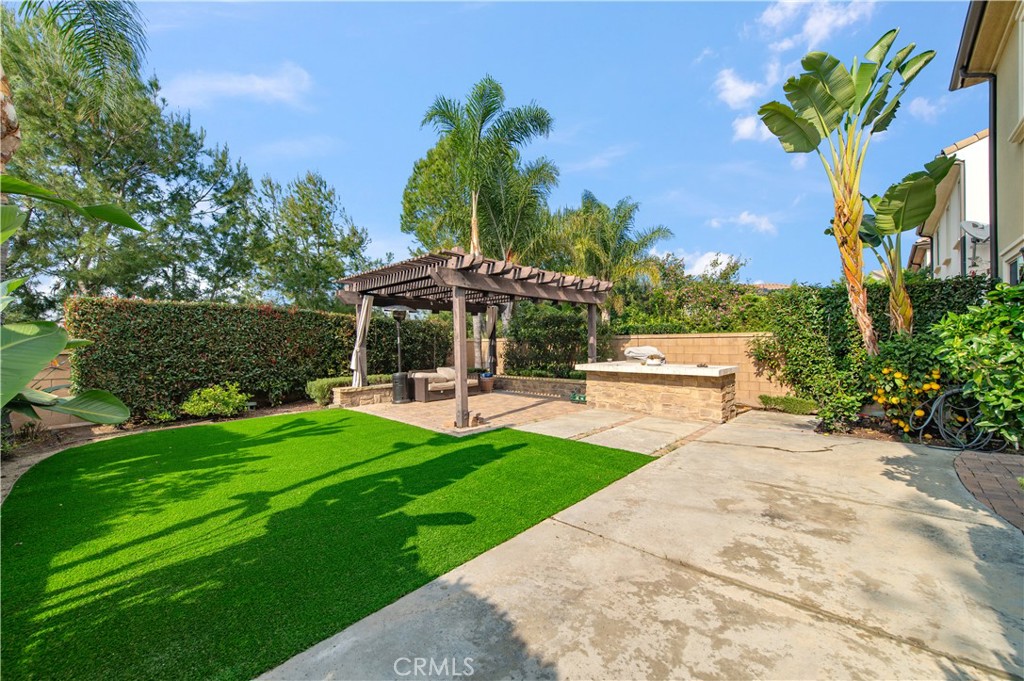 166 Desert Bloom Irvine, CA 92618 - Photo 15 of 36 a view of a swimming pool with lawn chairs under an umbrella