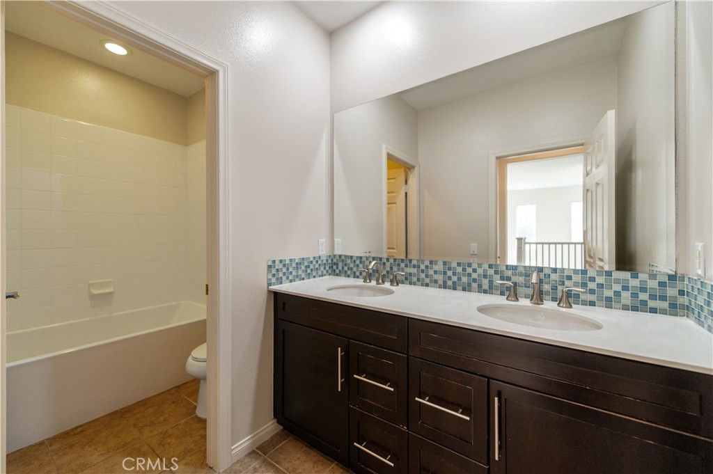 166 Desert Bloom Irvine, CA 92618 - Photo 29 of 36 a bathroom with a granite countertop sink a mirror and a bathtub